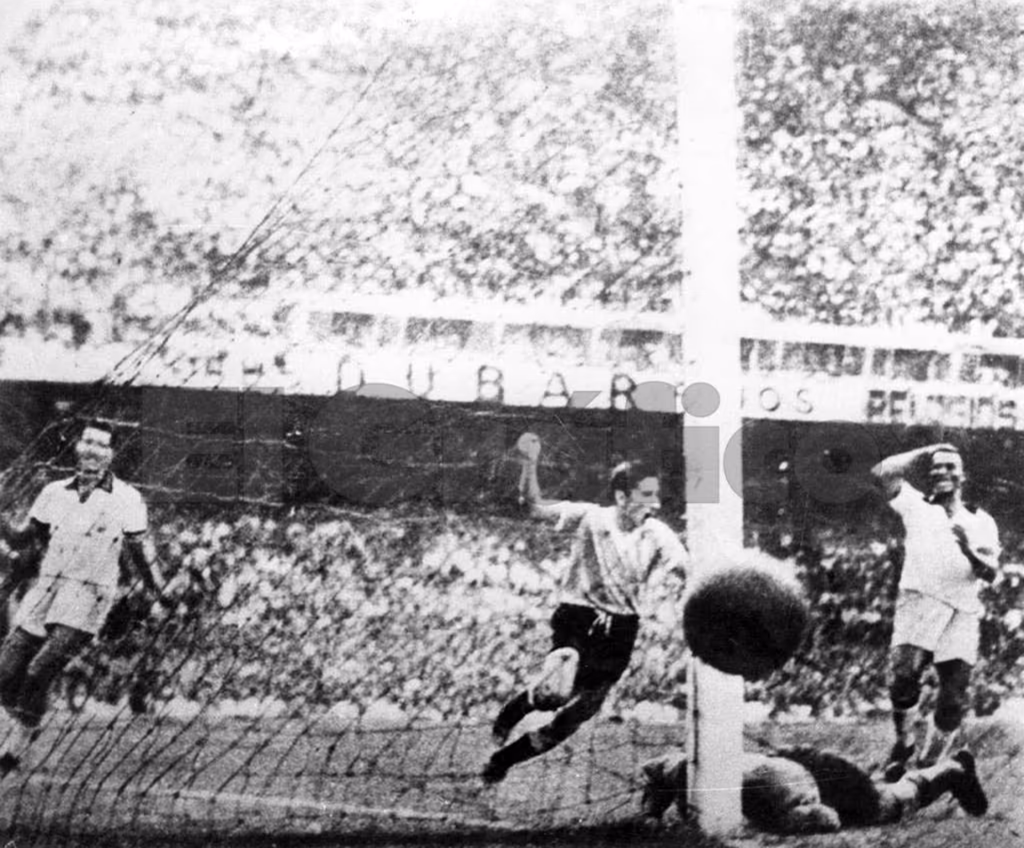 Schwarz-Weiß-Pressefoto von Alcides Ghiggias Tor zum 2–1: der Ball im Netz, der brasilianische Torwart am Boden, ringsum Spieler und dahinter die dicht besetzte Tribüne des Maracanã.